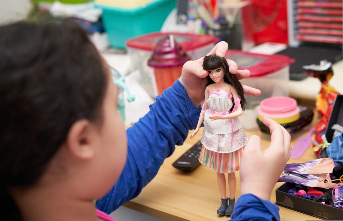 Mattel's free Barbie doll initiative rolled out in UK schools, has sparked backlash and criticism, with experts labelling it as "stealth marketing" and "repulsive "in the British Medical Journal (BMJ). The photo shows a young child playing with a doll.