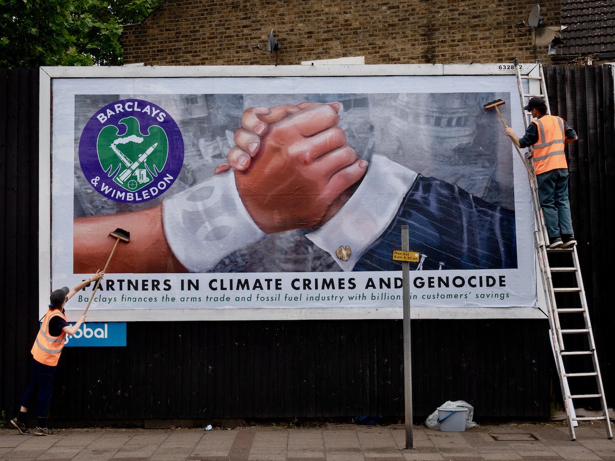 Hacked billboard reads "Partners in climate crisis and genocide". In a protest against Barclays' sponsorship of Wimbledon, activists from anonymous arts collective Brandalism have replaced commercial billboard, bus stop and tube ads surrounding the prestigious tennis tournament, which opens on Monday, with hard-hitting artworks targeting Barclays' links to arms companies and the climate crisis. 30/6/24 Photo Tom Pilston.